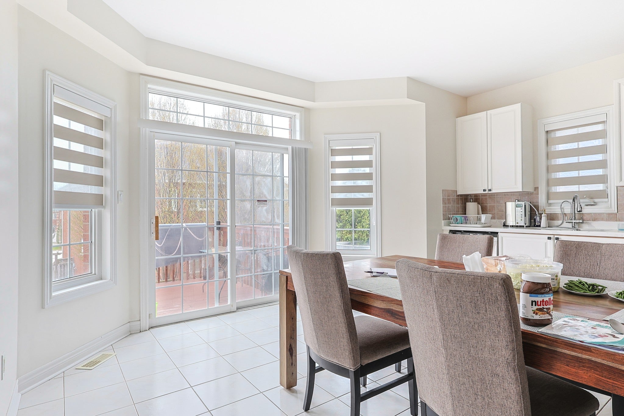 Zebra blind beside patio doors in a bright dining area