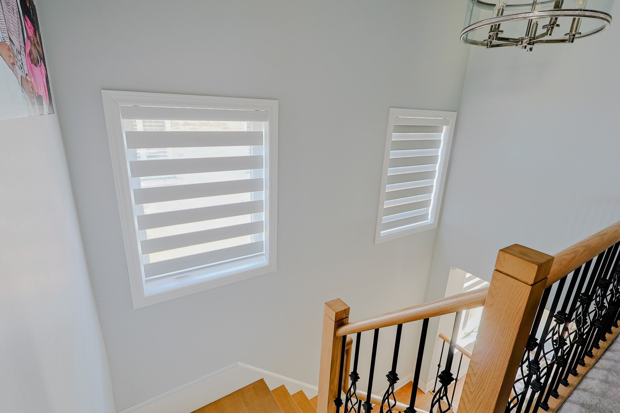 Two zebra blinds installed beside an interior staircase