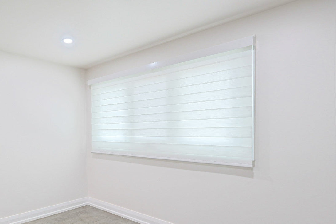White roller shade installed on a wide bedroom window