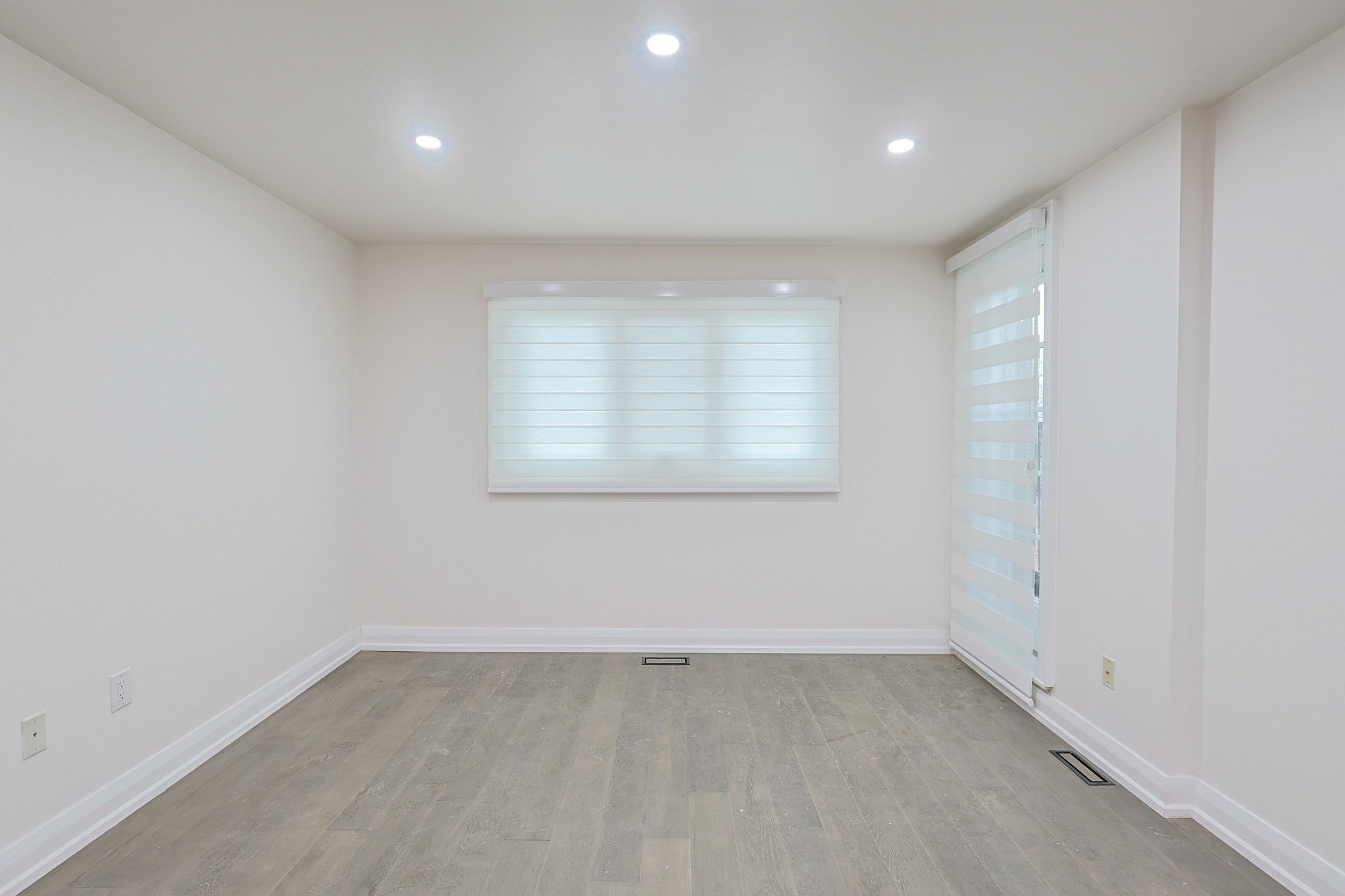 White custom blinds installed in a bright empty room